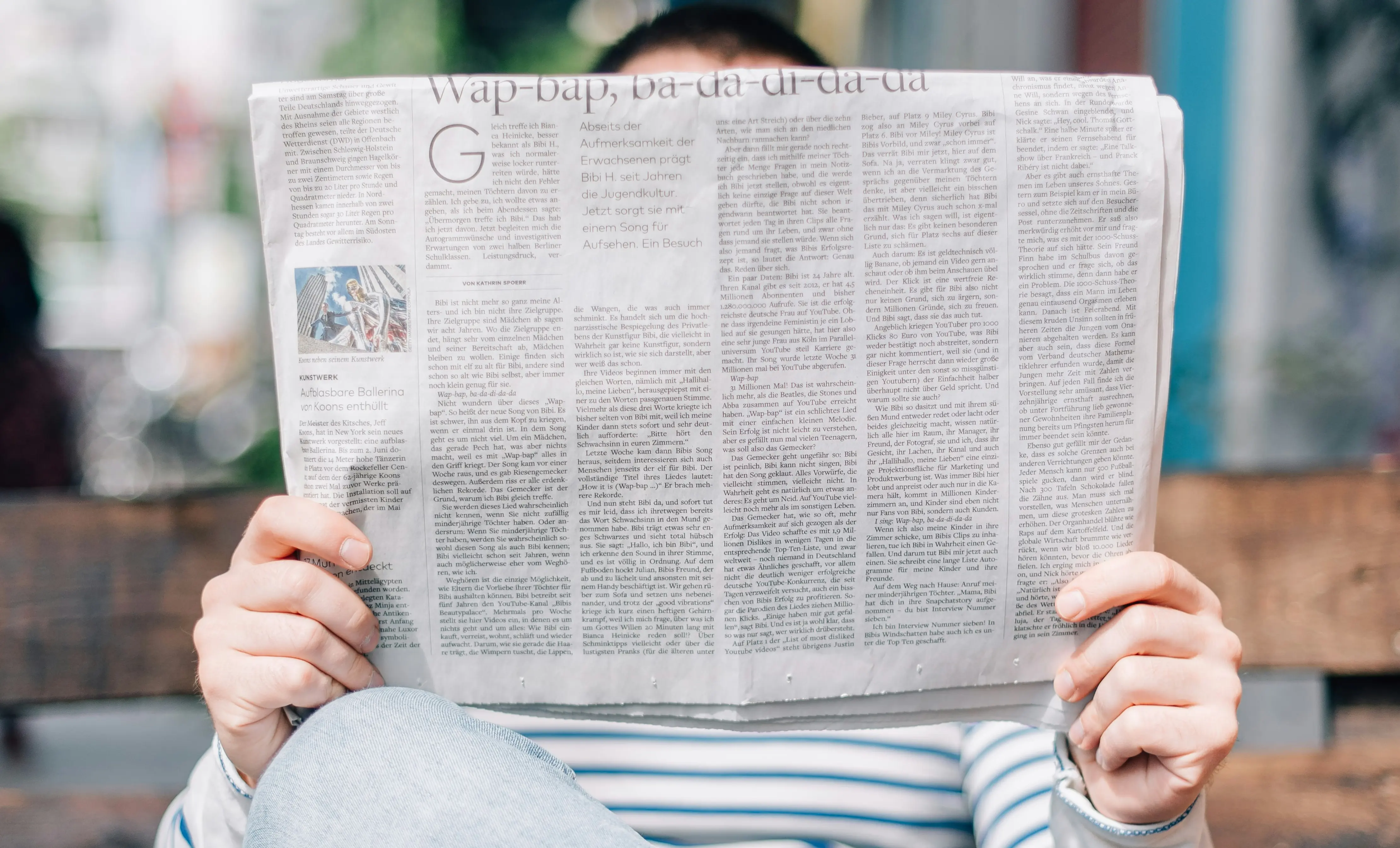 a newspaper being held in front of a person
